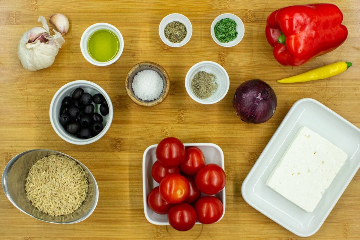 The ingredients are on the chopping board - tomatoes, rice, feta cheese, olives, onion, bell pepper, garlic, chilli | Hurry The Food Up