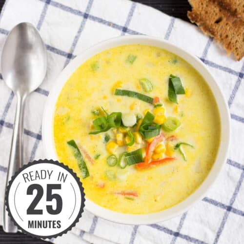 A bird’s eye view of a bowl of chowder, sprinkled with green onions, on a checked kitchen towel with a time stamp in the bottom left hand corner | Hurry The Food Up