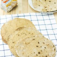 Flour Tortillas lie on the checkered tablecloth. Next to it there are a package of flour, olive oil and a plate with tortillas | Hurry The Food Up - 6