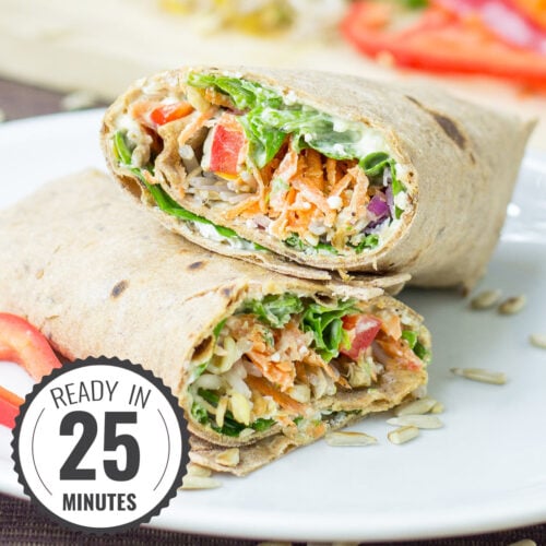 Two veggie wraps sit on the white plate with a time stamp in the bottom left hand corner | Hurry The Food Up