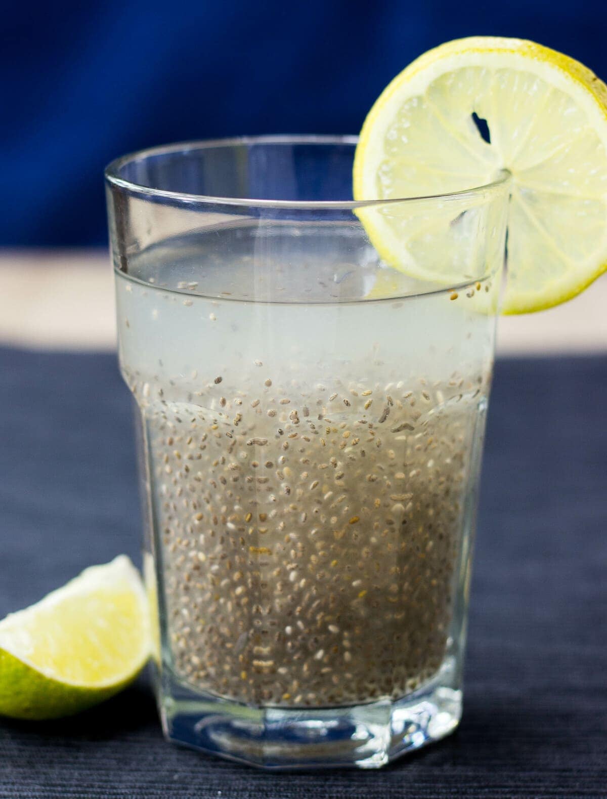 A glass of chia fresca (iskiate) is placed on a table with a slice of lime on its rim and by its side | Hurry The Food Up