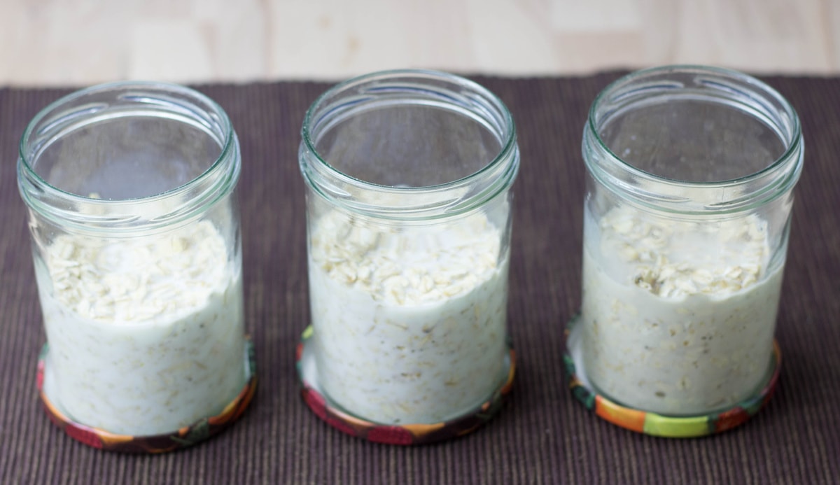 Three jars of oats with milk, lined up on a brown place mat | Hurry The Food Up