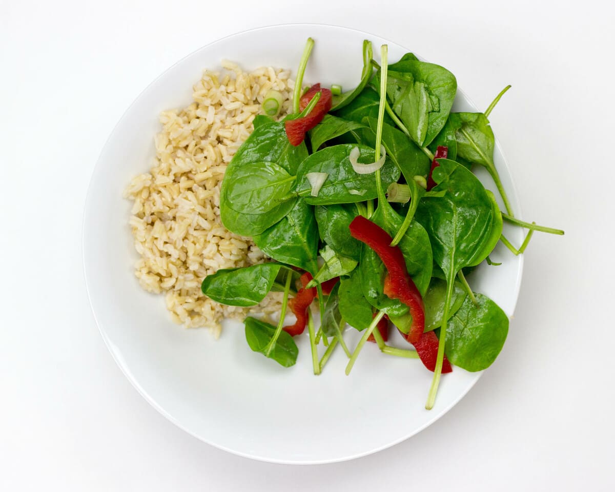 Basmati rice and vegetables are plated on a white bowl and placed on a table | Hurry The Food Up