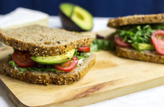 twee sandwiches worden geserveerd op de snijplank | haast het eten