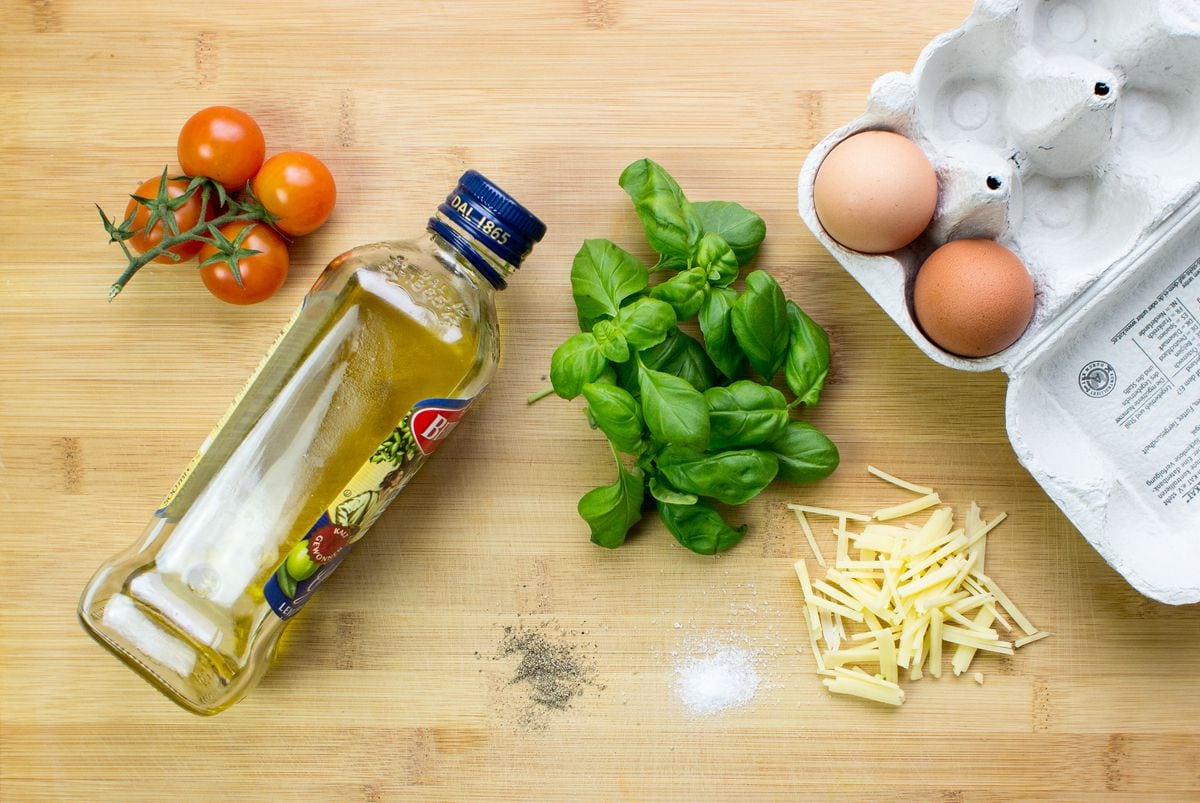 The ingredients for a tomato omelette, including olive oil, basil, cheese & eggs | Hurry The Food Up