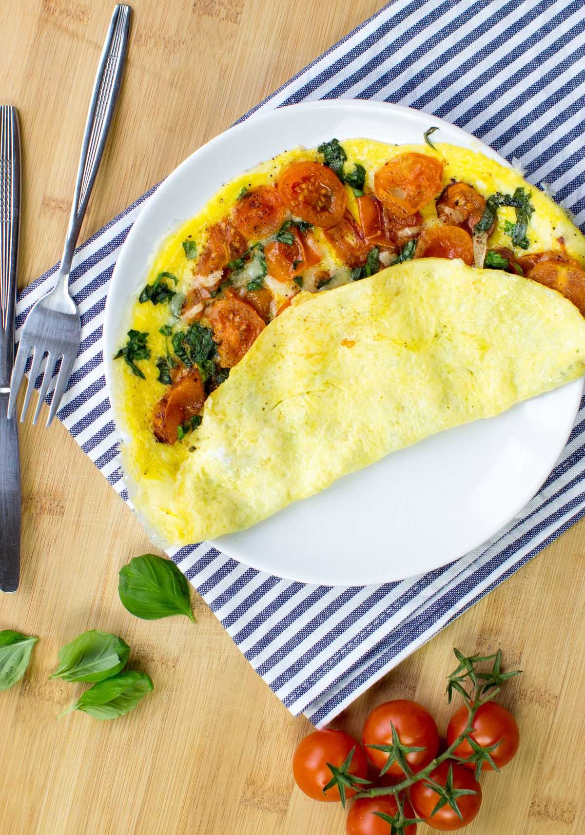 The tomato omelette is served on a plate, on top of a striped blue and white tea towel. | Hurry The Food Up