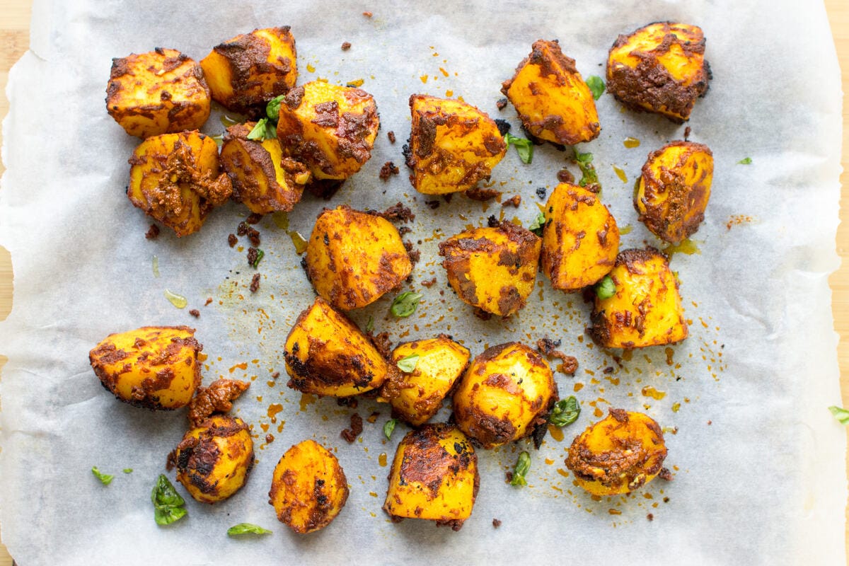 Irish Bombay Potatoes on parchment paper, having been partially baked | Hurry The Food Up