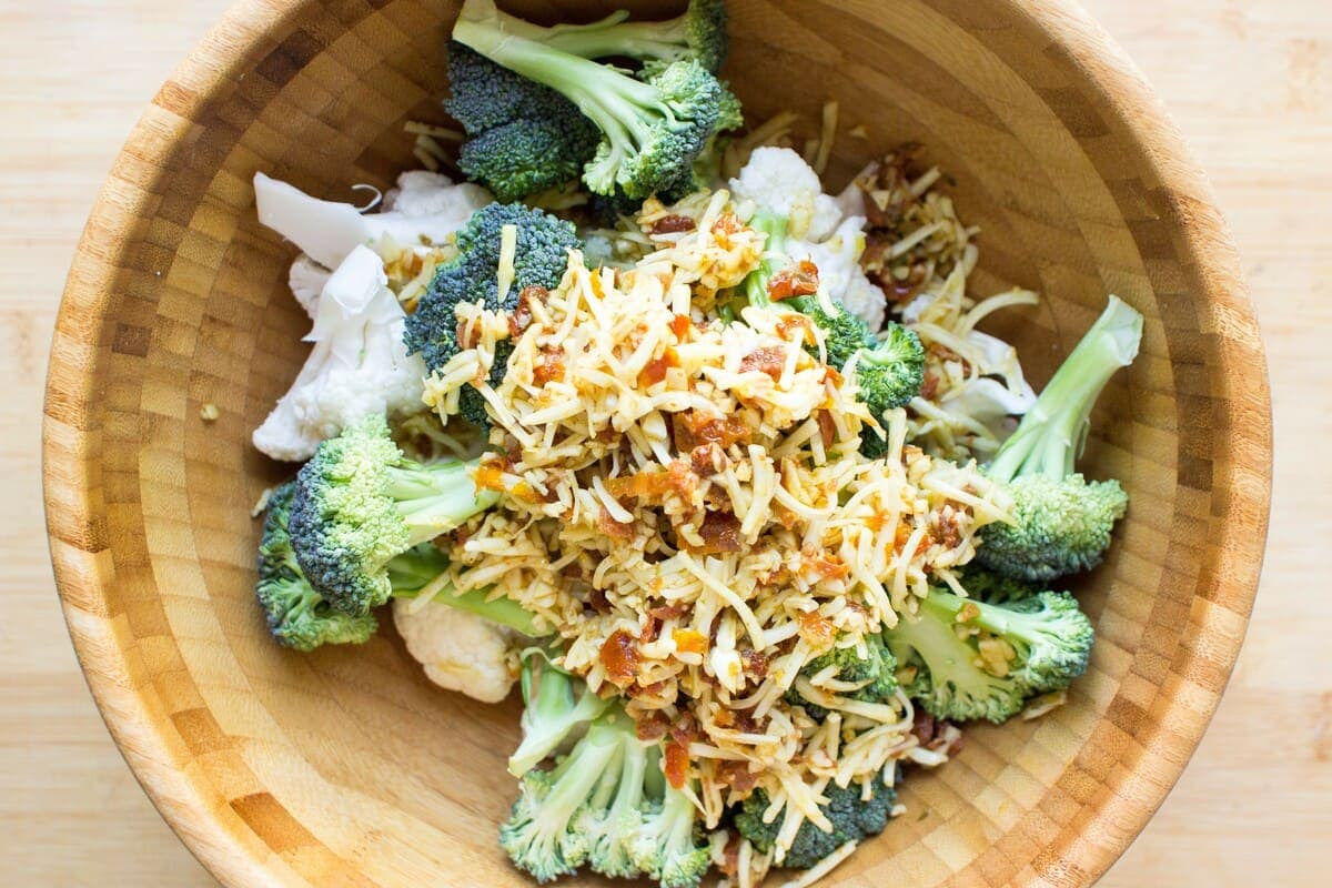 All the ingredients for oven roasted broccoli and cauliflower are in a wooden bowl | Hurry The Food Up