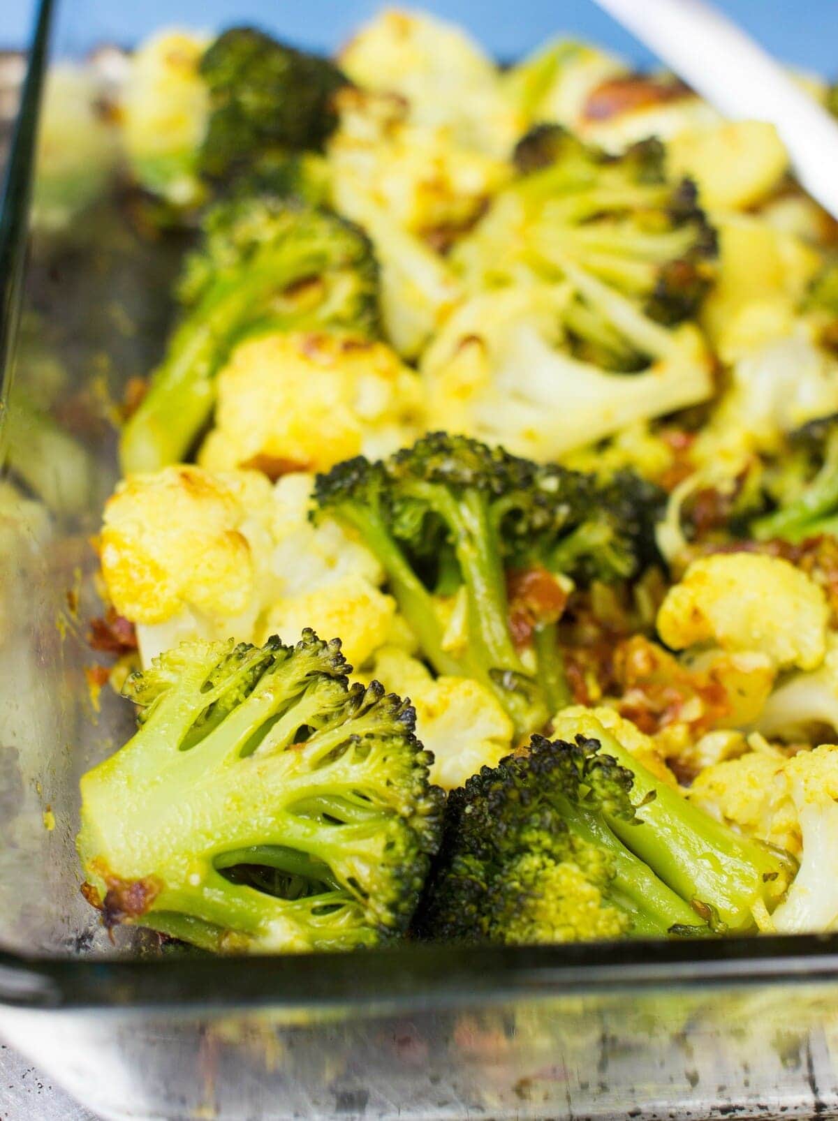 Oven roasted broccoli and cauliflower florets are placed in a glass baking tray | Hurry The Food Up