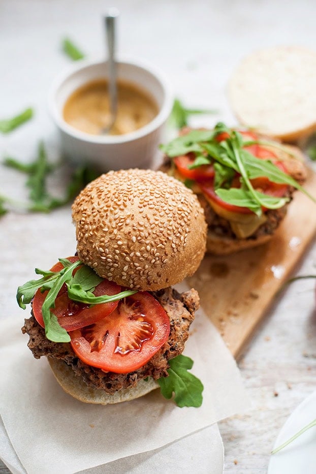 Two Black Bean Burgers served on a chopping board with sauce | Hurry The Food Up