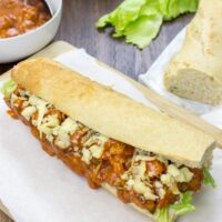 Vegetarian coronation chicken lies on the wooden board, which is covered by white paper. Around it, there are some bowls and bread | Hurry The Food Up - 7