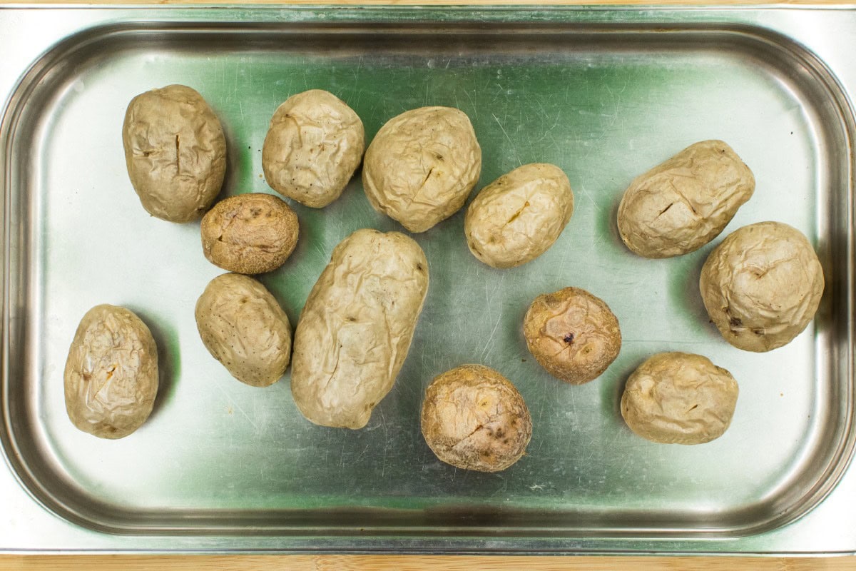 A tray with microwave baked potatoes, which are ready for the filling | HurryTheFoodUp