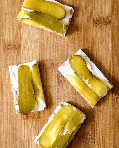 Gherkin on crispbread snack on wooden surface