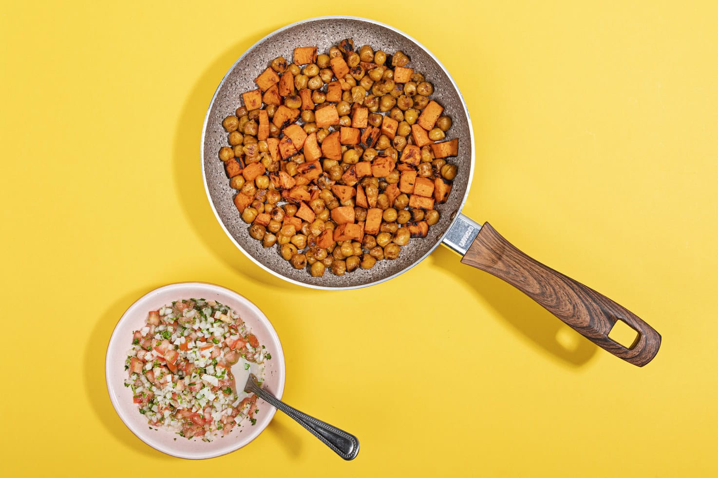 Sweet potato and chickpeas in a frying pan, alongside a bowl of homemade pico de gallo. | Hurry The Food Up