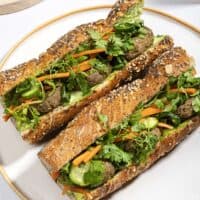 Two lentil banh-mi sandwiches on a plate, filled with lentil patties and vegetables | Hurry The Food Up - 8