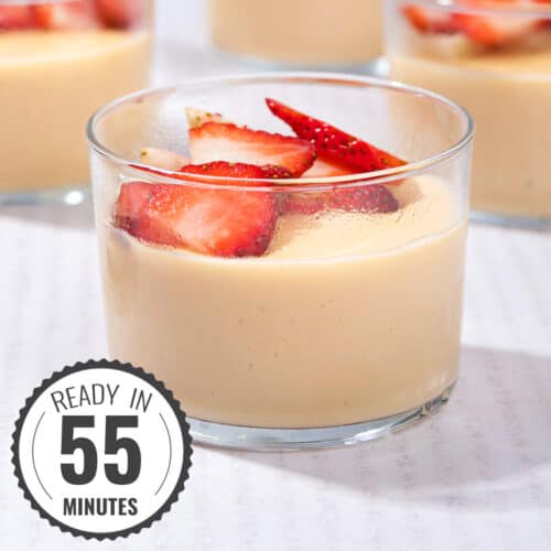 Ramekins of custard topped with chopped strawberries on a table with a time stamp in the bottom left hand corner | Hurry The Food Up