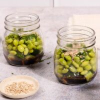 On a stone table sits two mason jars containing cucumber and edamame smashed salad | Hurry The Food Up - 8