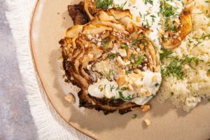 herby roasted cabbage steaks and couscous on a ceramic plate, sitting on a cream cloth | Hurry The Food Up