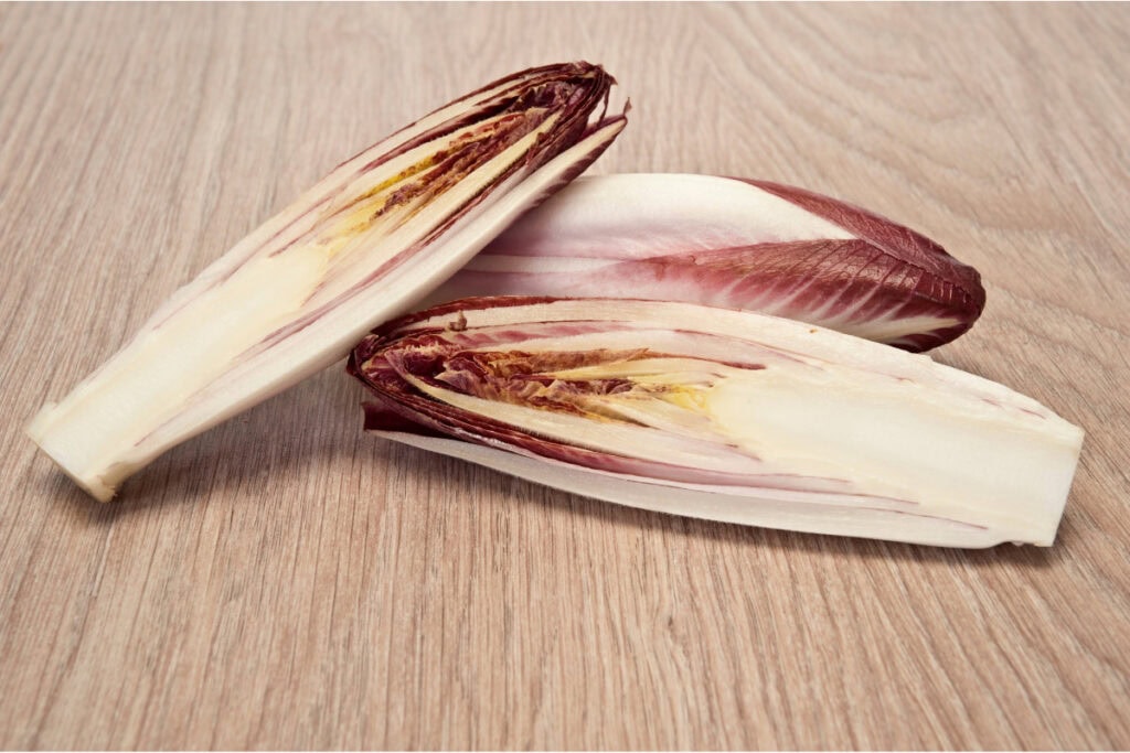 Three pieces of chicory lie on the wooden surface | Hurry The Food Up