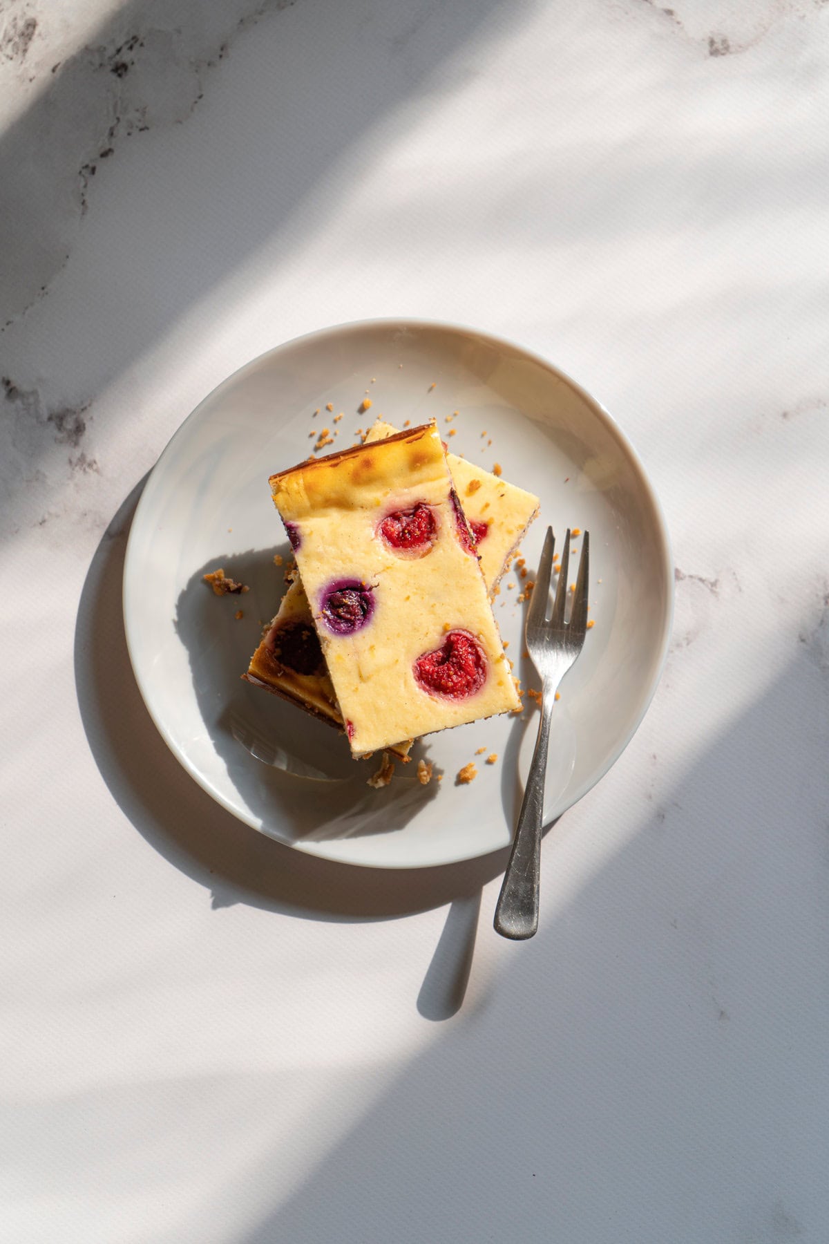 Bird's-eye view of cottage cheesecake that is on the white plate with fork | Hurry The Food Up