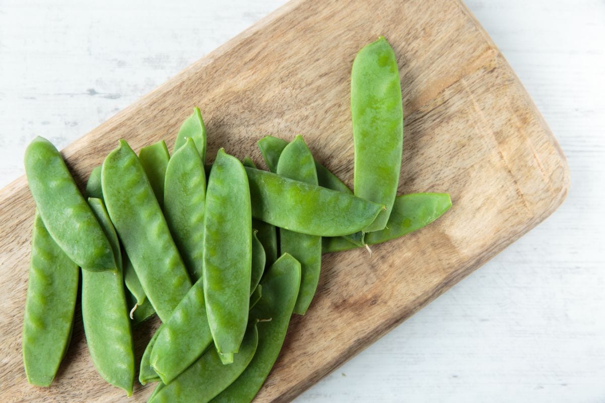 Mangetout on a wooden chopping board shot from above | Hurry The Food Up