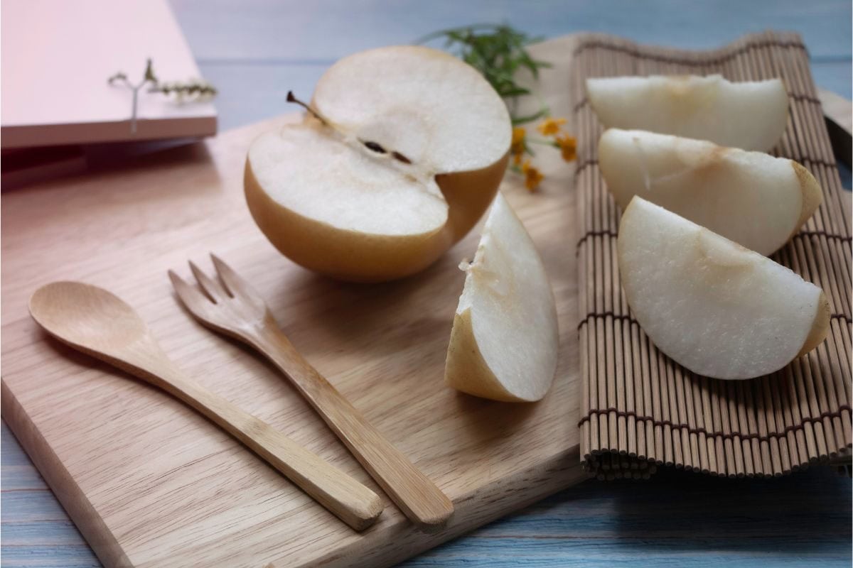 A Korean pear on a wooden board, half chopped into slices | Hurry The Food Up