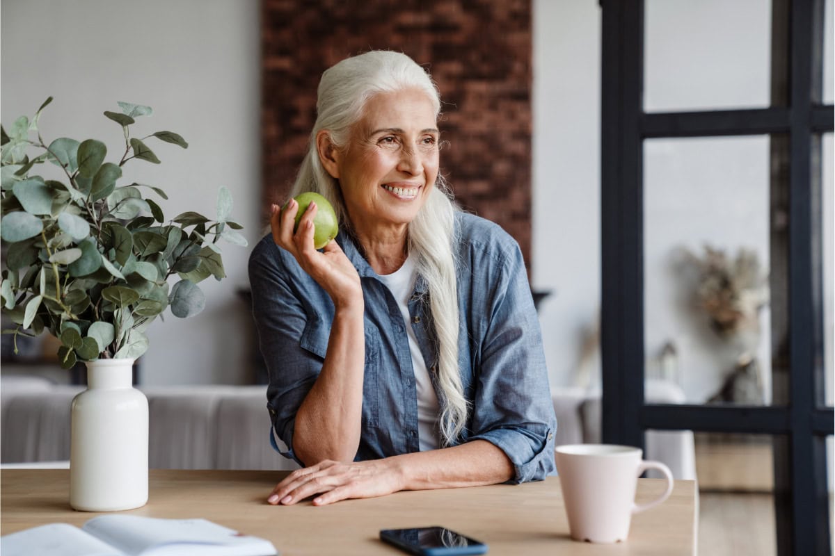 An elderly woman holds a green apple in her hand | Hurry The Food Up