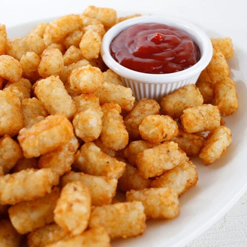 Tater tots with tomato sauce on a plate