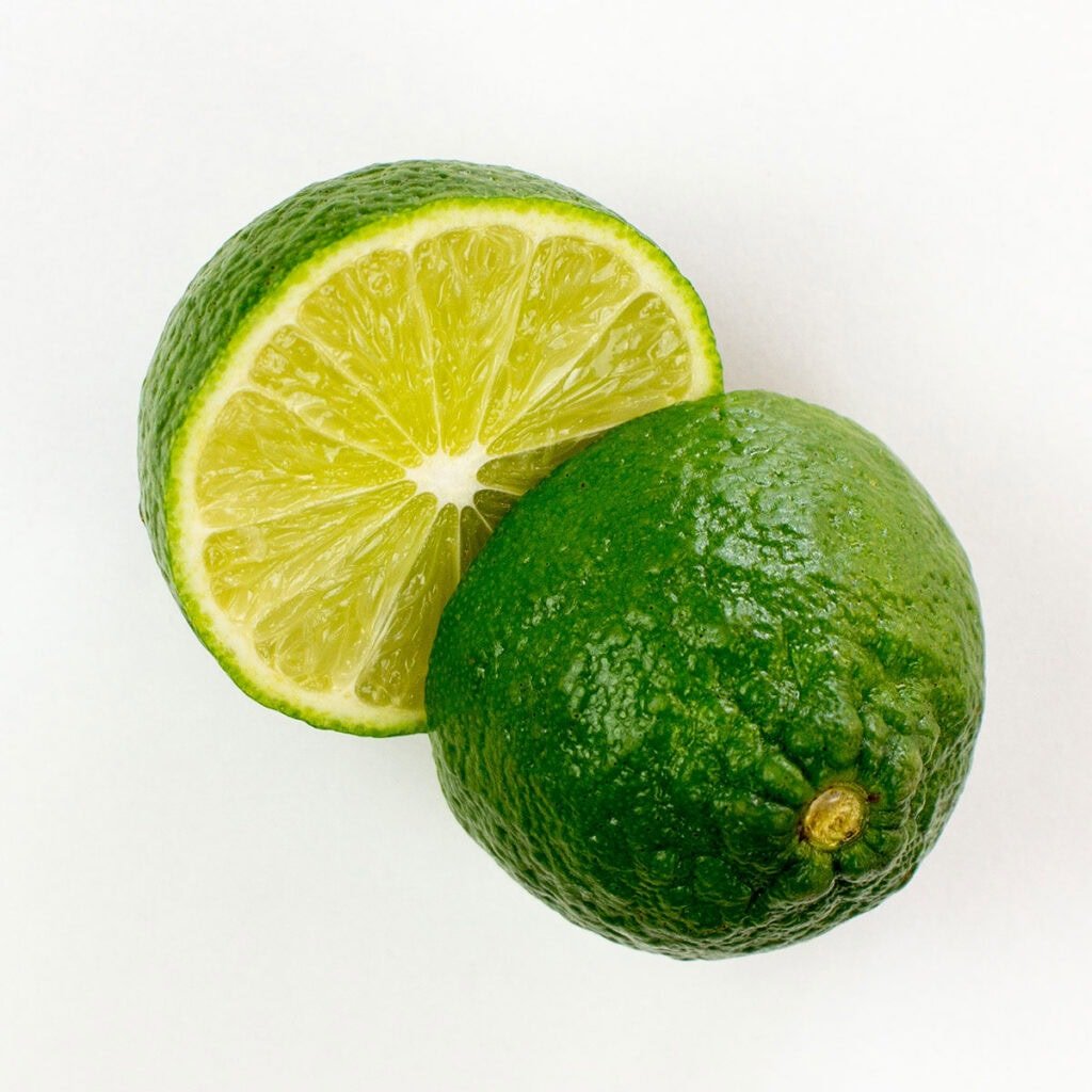 Two lime halves on white surface