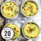 Four white ramekins filled with Caprese Quiche, featuring a yellow egg mixture with green herbs and pine nuts, placed on a sheet of aluminum foil on a textured surface with a timestamp in the left corner.