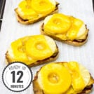 A white surface with four pieces of Hawaiian Tofu Toast topped with melted cheese and pineapple slices, arranged in a vertical line with a timestamp in the left corner.
