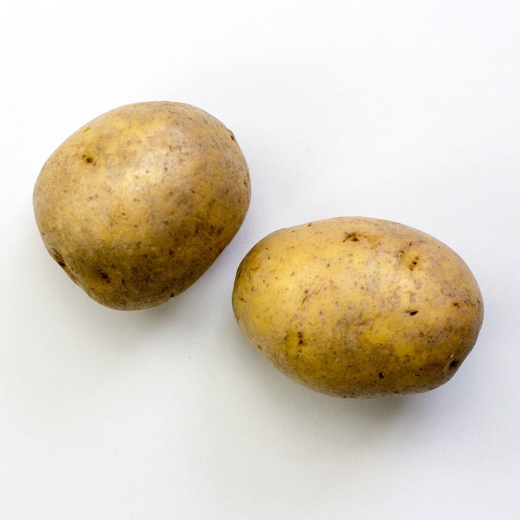 Two potatoes on white surface