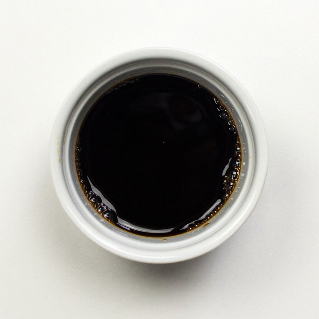 A bowl of soy sauce on white background
